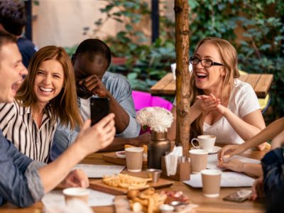 sincere-laugh-showing-picture-smartphone-casual-meeting-with-best-friends-restaurant-terrace_8353-10272